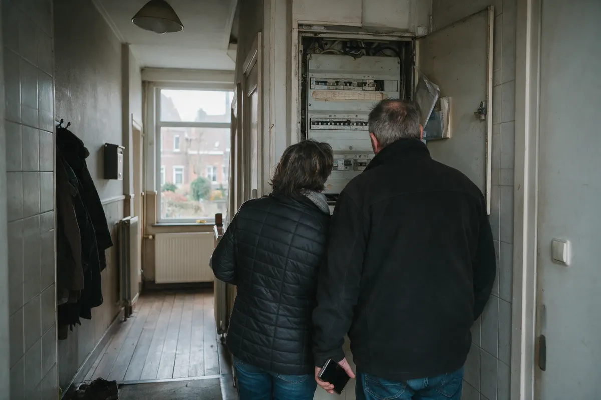 Vlaams gezin bij de meterkast, waar een stekkerbatterij aangemeld moet worden