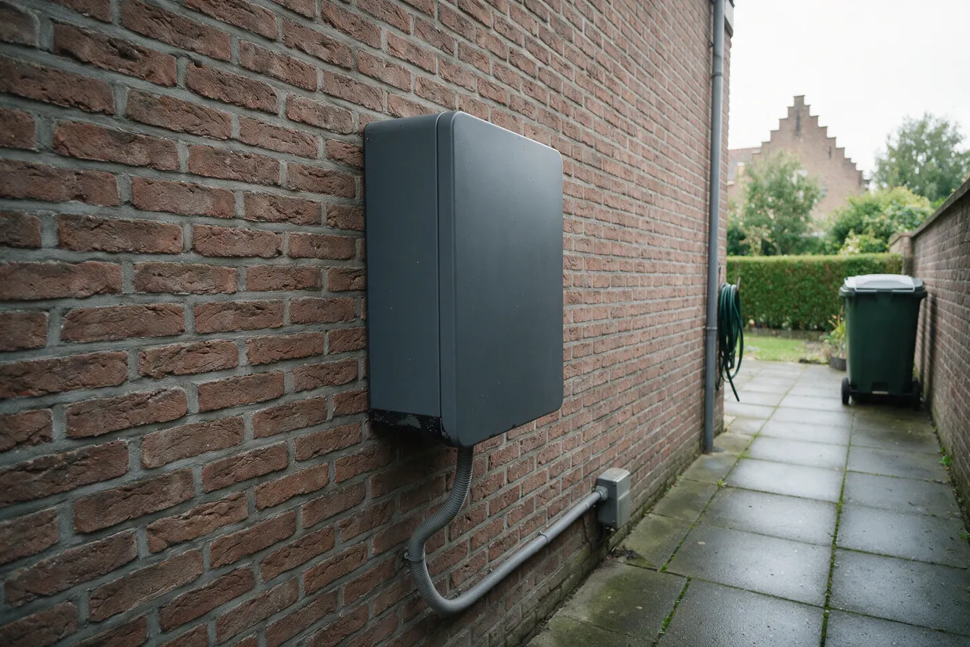 Thuisbatterij buiten plaatsen: onbedrukte batterijkast tegen de zijgevel van een Vlaamse woning