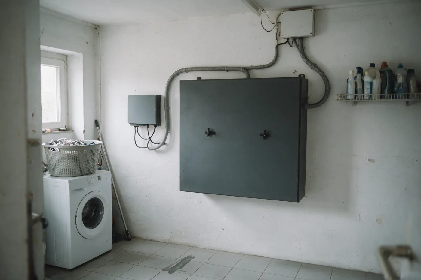 Onbedrukte batterijkast en omvormer in een Belgische bergruimte, de installatie die je financiert