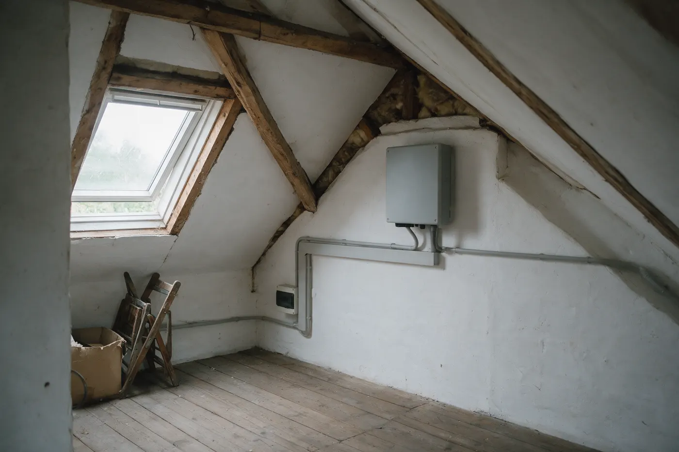 Omvormer van een zonnepaneleninstallatie met groenestroomcertificaten op een Vlaamse zolder, met kabelgoten naar de meterkast