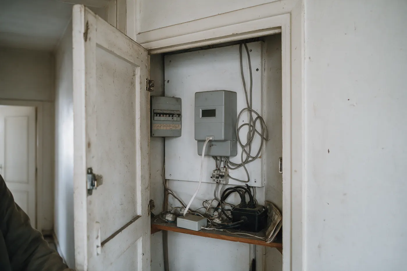 Open meterkast in de gang van een Vlaamse woning met digitale meter en een datakabel voor de P1-poort van een thuisbatterij