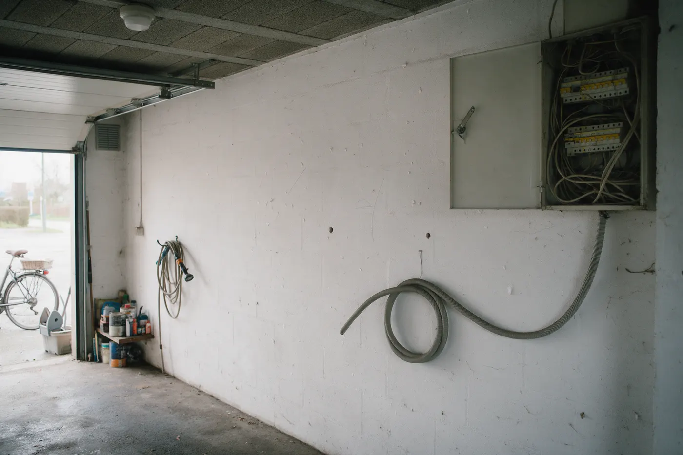 Lege garagewand naast een open zekeringkast, met potloodmarkeringen waar een thuisbatterij zou komen