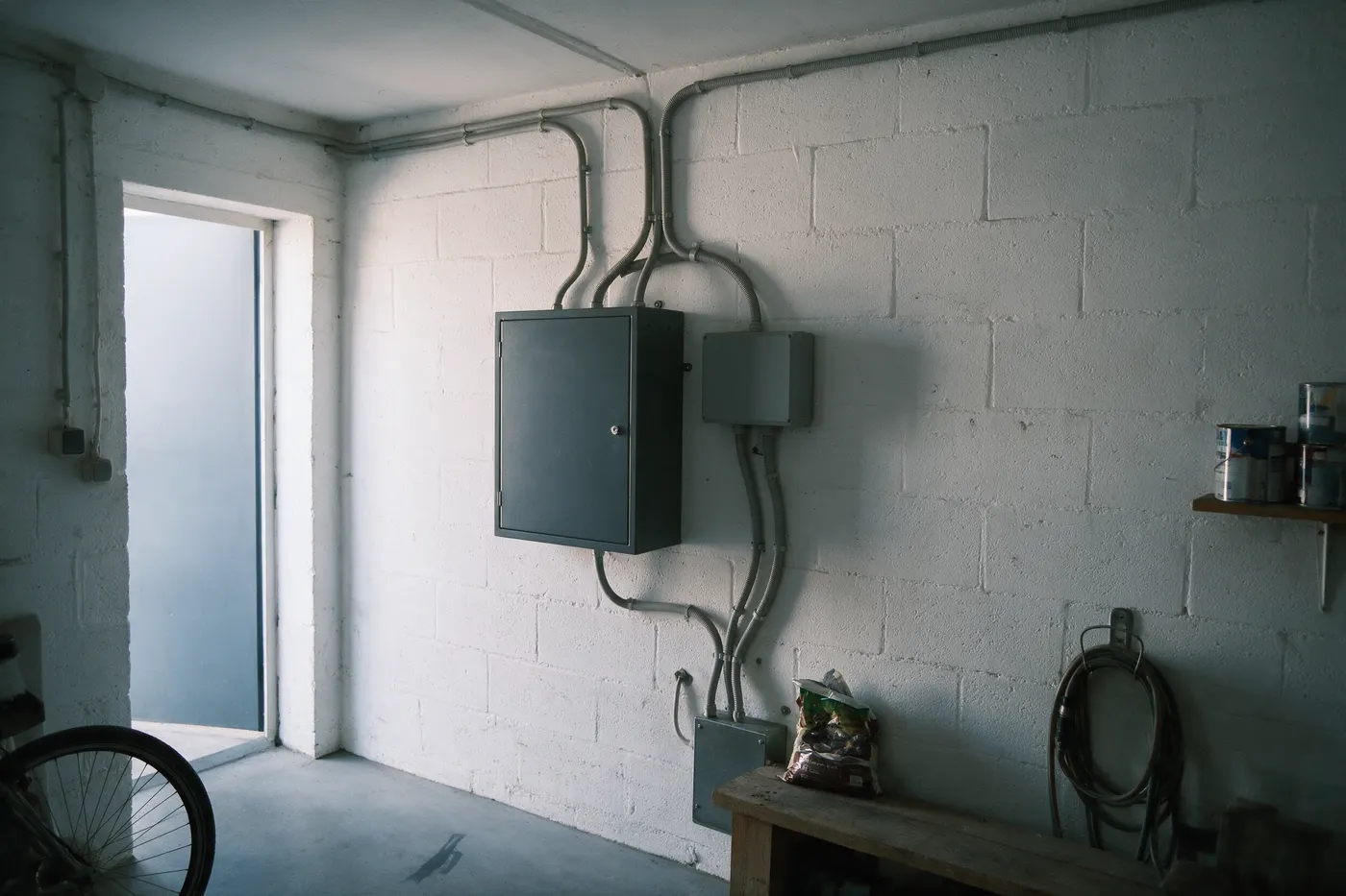 Thuisbatterij en omvormer samen aan de muur in een Belgische berging